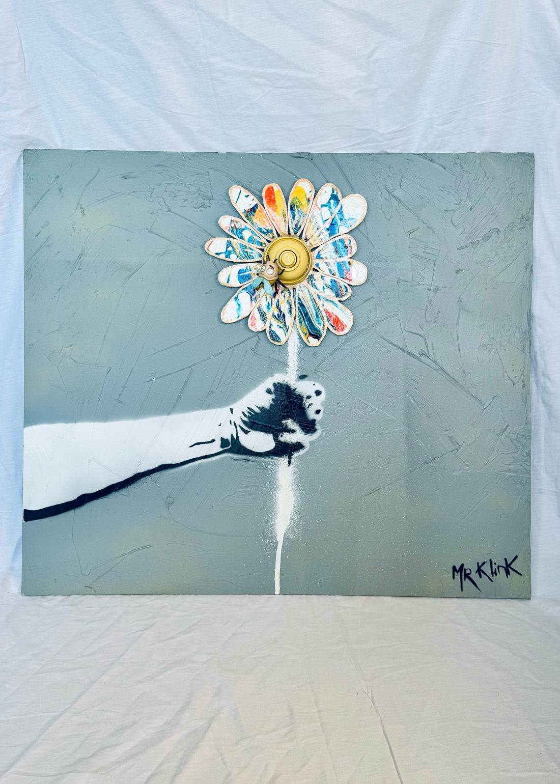Passe-Fleur — Mr Klink, 2026. Installation street art, bras en gouttière avec fleur en bois peinte et BZzz résine.